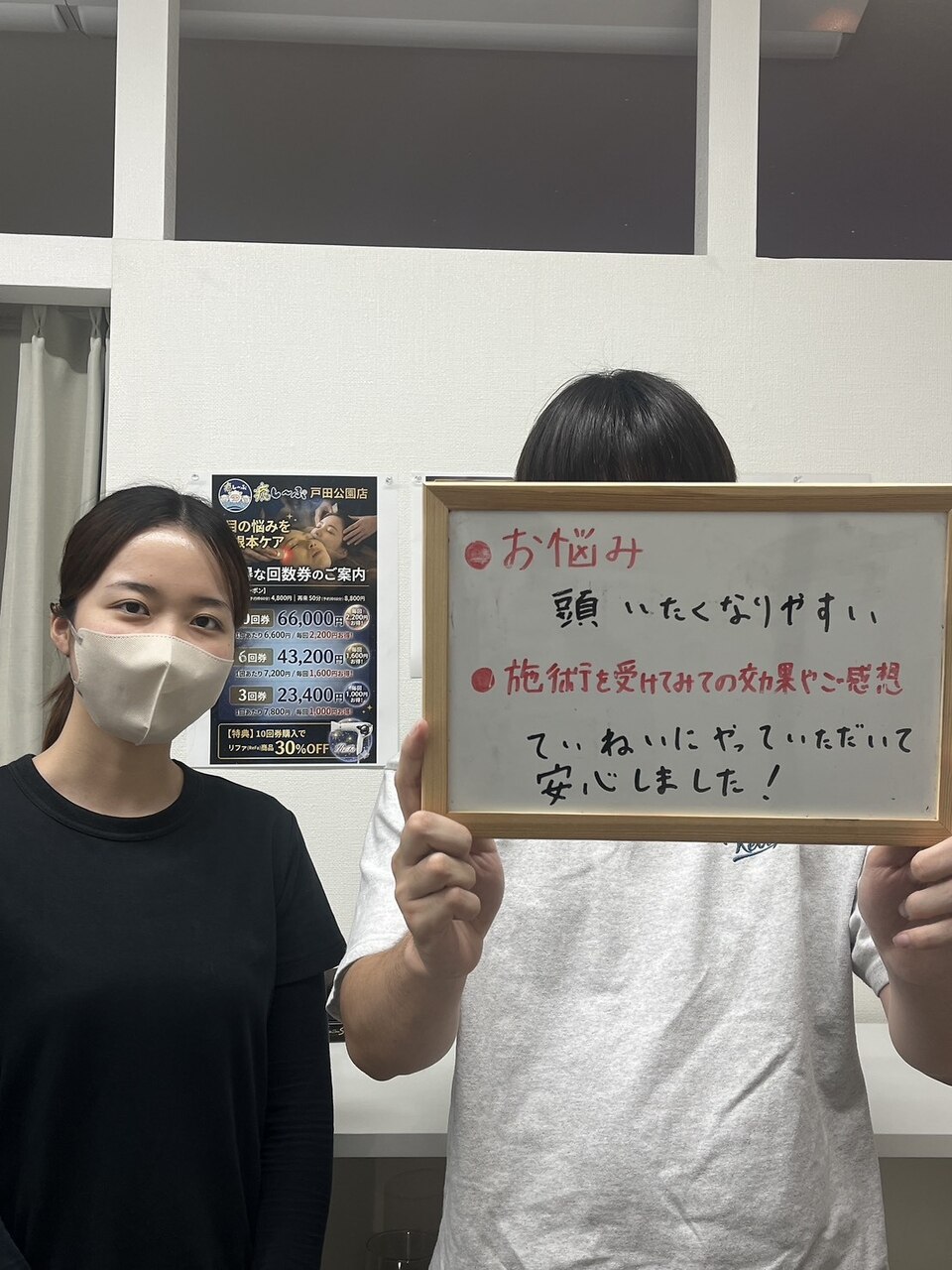 頭が痛くなりやすい悩みについて感想ボードを持つお客様とスタッフ