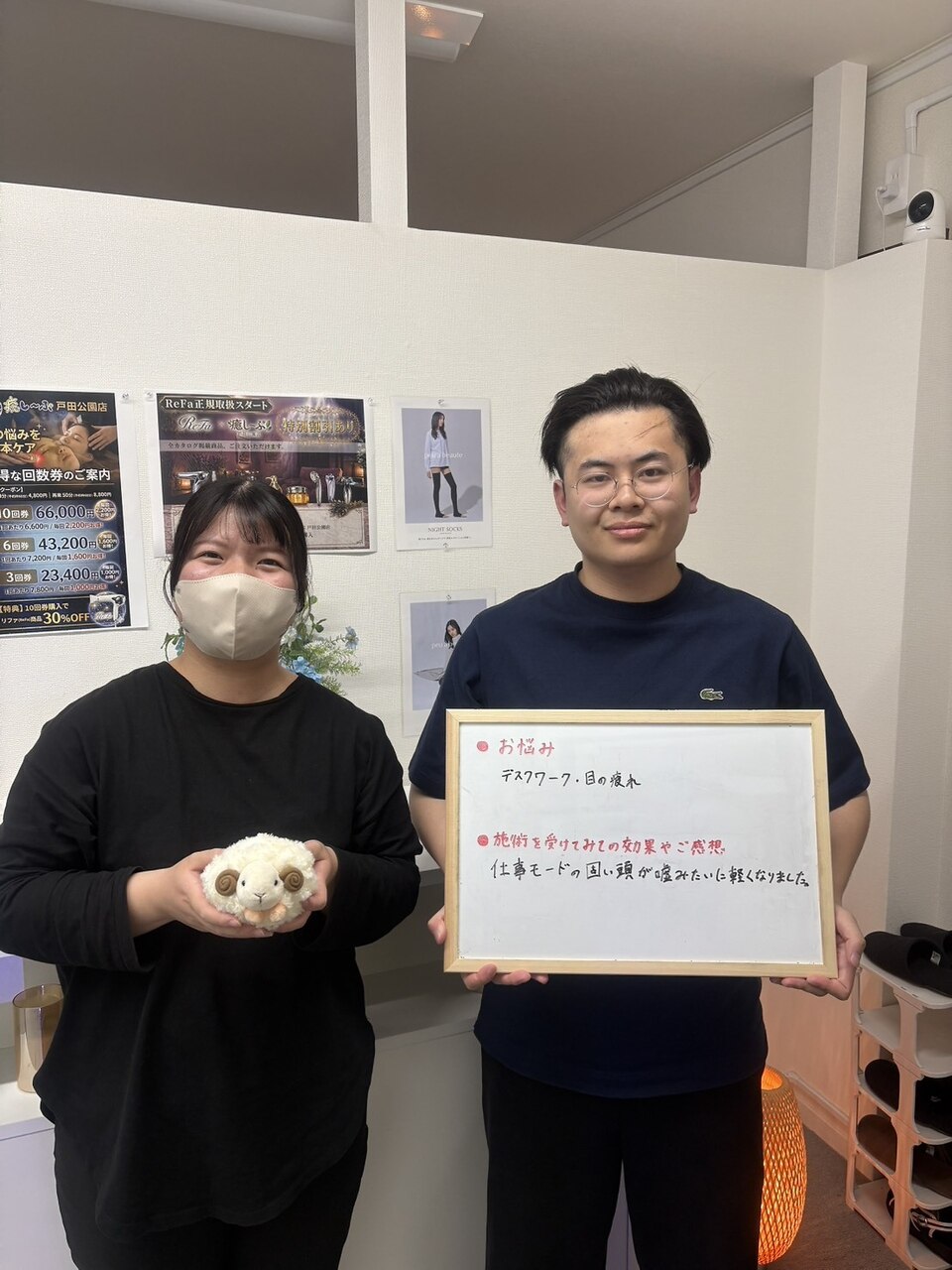 デスクワークと目の疲れについて感想ボードを持つお客様とスタッフ